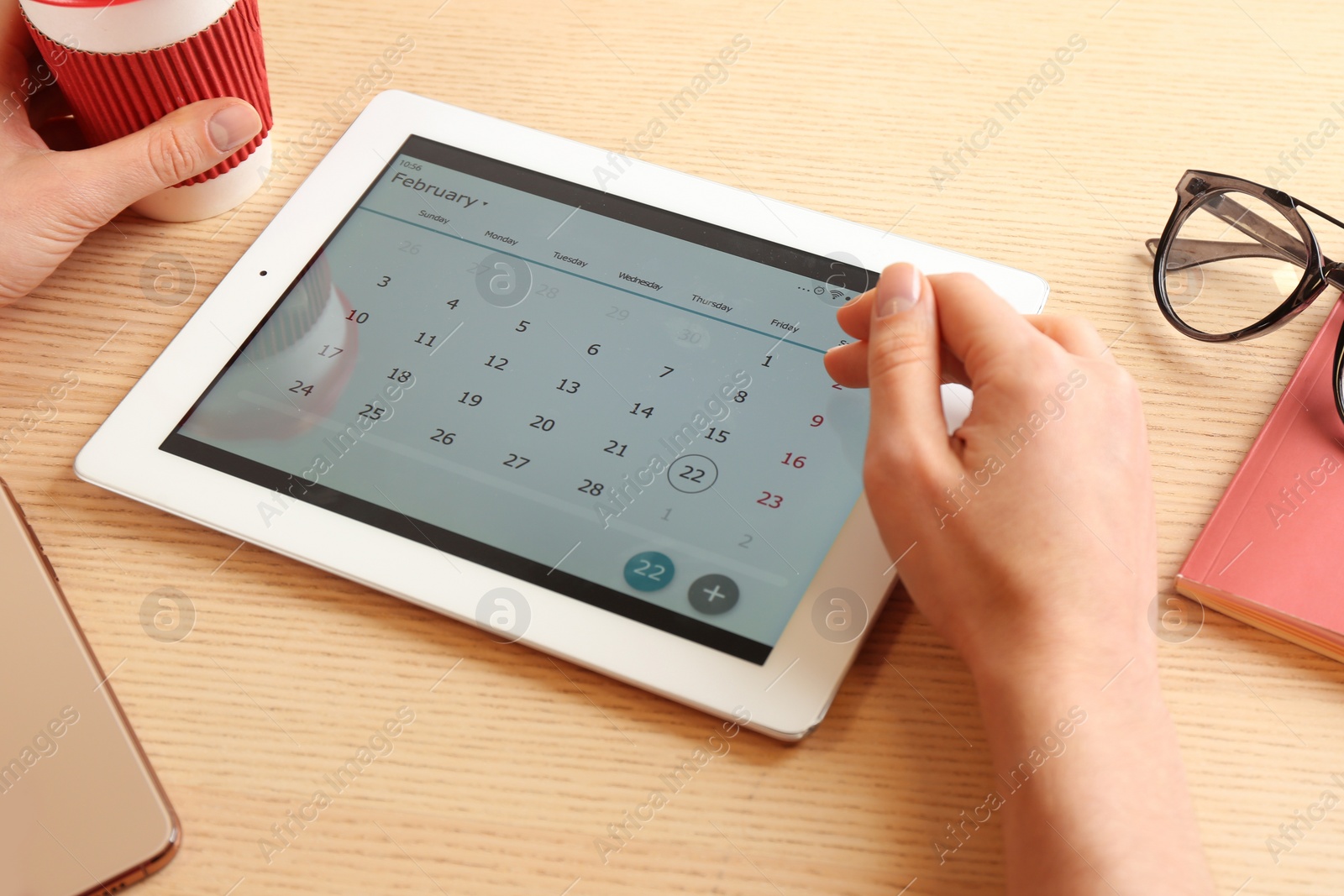 Photo of Woman using calendar app on tablet in office, closeup