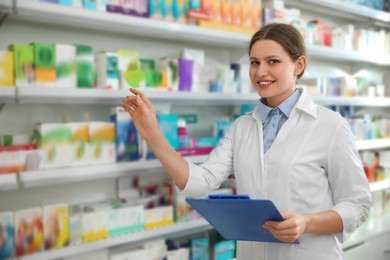 Photo of Professional pharmacist with clipboard in modern drugstore