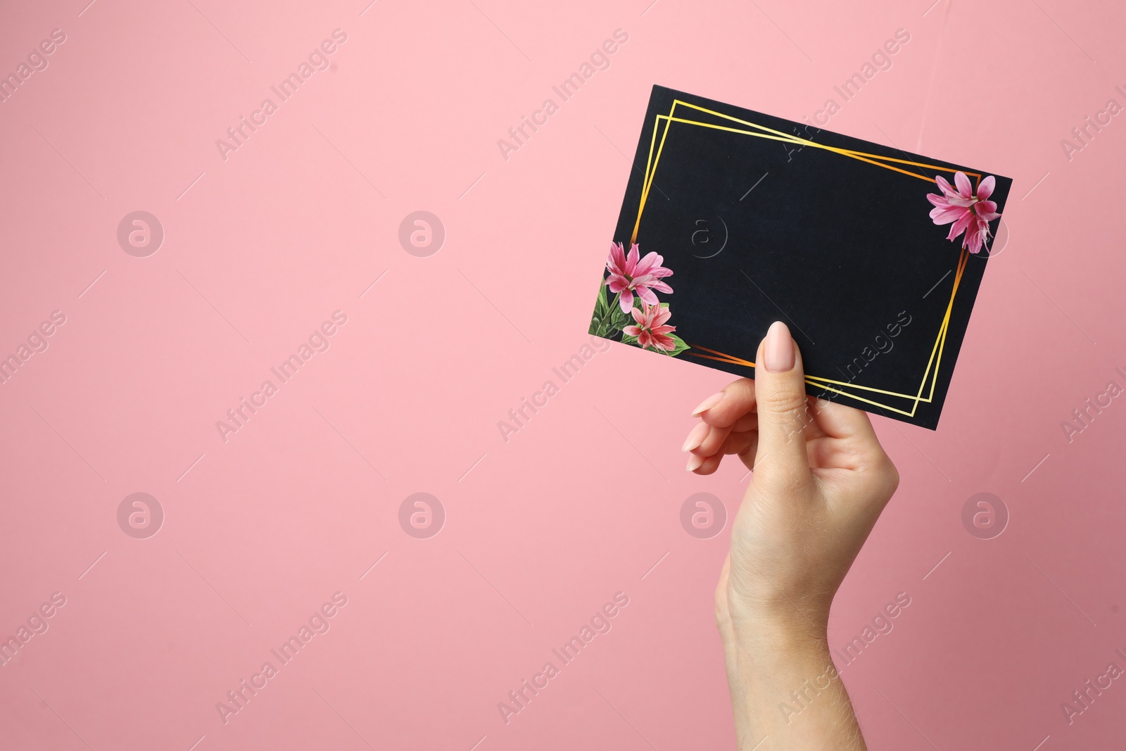 Photo of Woman holding blank invitation card on pink background, closeup. Space for text