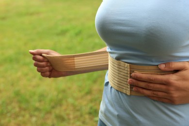 Closeup view of woman with orthopedic corset on blurred background