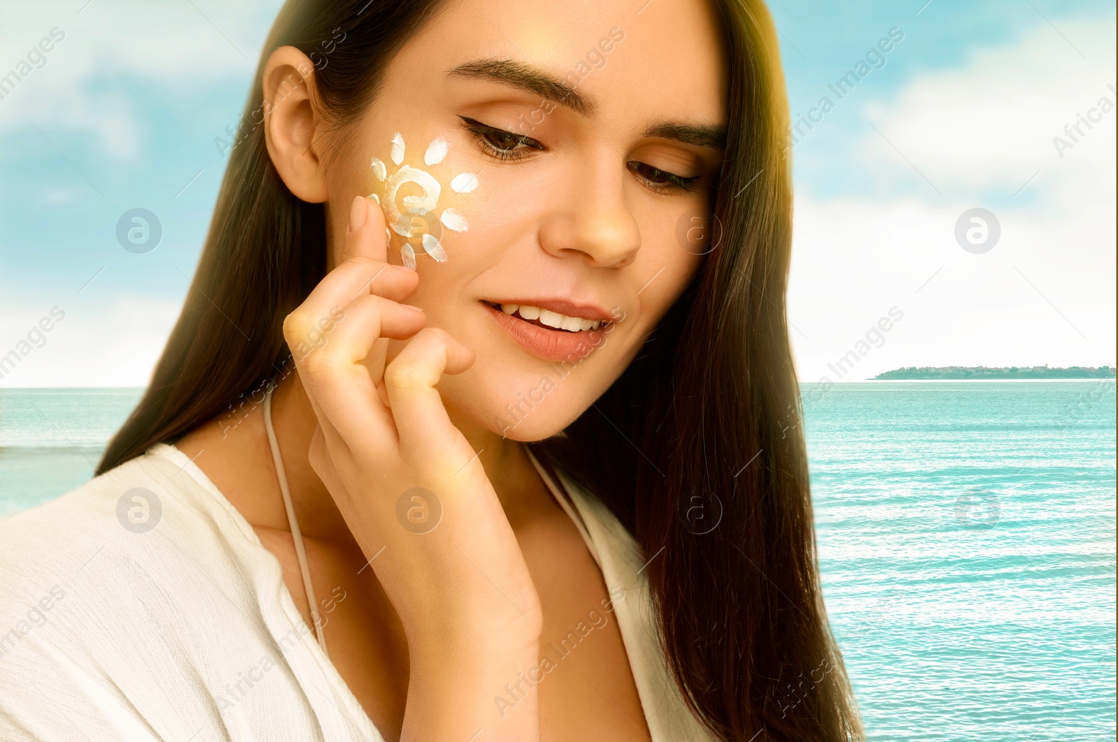 Image of Sun protection. Beautiful young woman applying sunblock onto face on beach, closeup