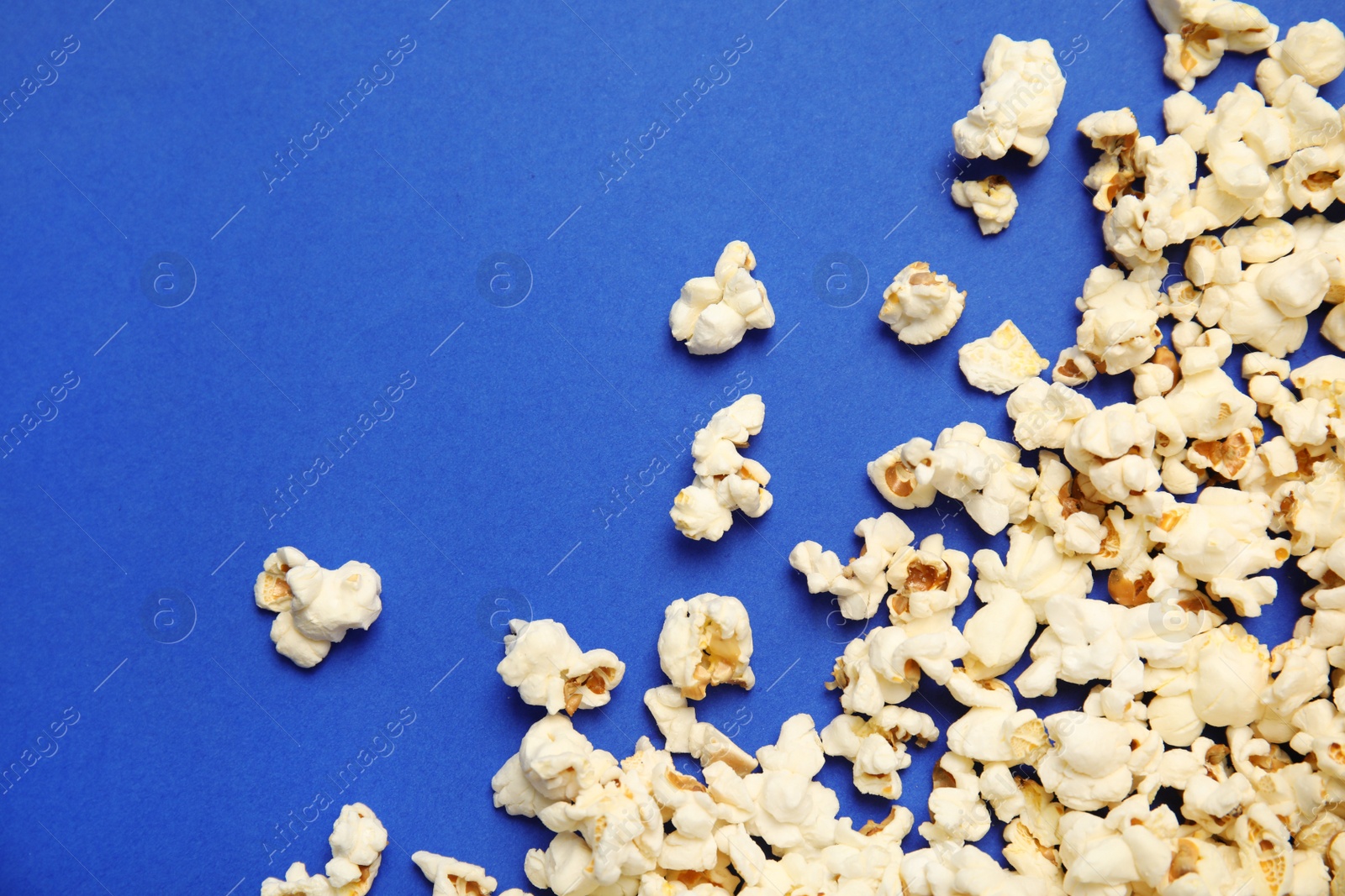 Photo of Tasty fresh popcorn on color background, top view