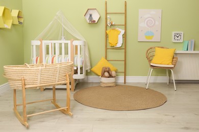 Baby room interior with stylish furniture and wicker cradle
