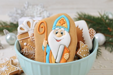 Tasty gingerbread cookies in bowl on white table, closeup. St. Nicholas Day celebration