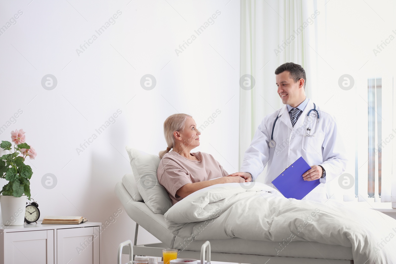 Photo of Doctor visiting his patient in hospital ward