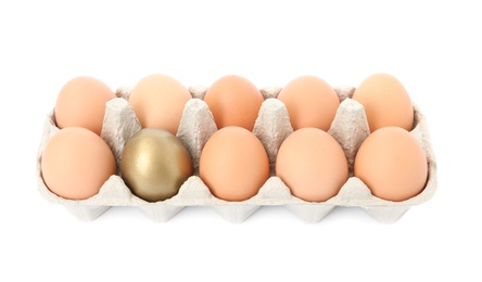 Photo of Eggs with golden one in carton on white background