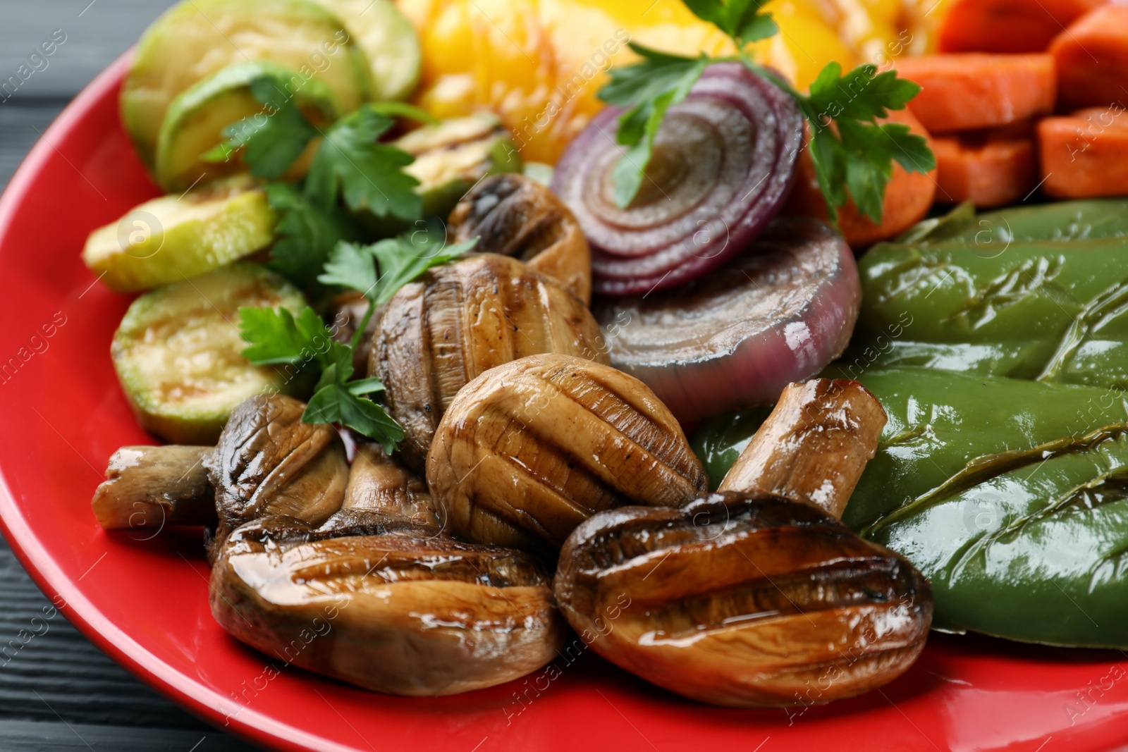 Photo of Delicious grilled vegetables on red plate, closeup