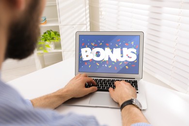 Bonus gaining. Man using laptop at white table indoors, closeup. Illustration of falling confetti and word on device screen