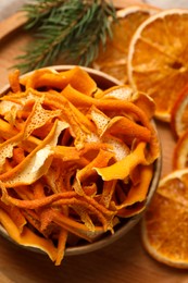 Photo of Dry orange peels and slices on wooden board, above view