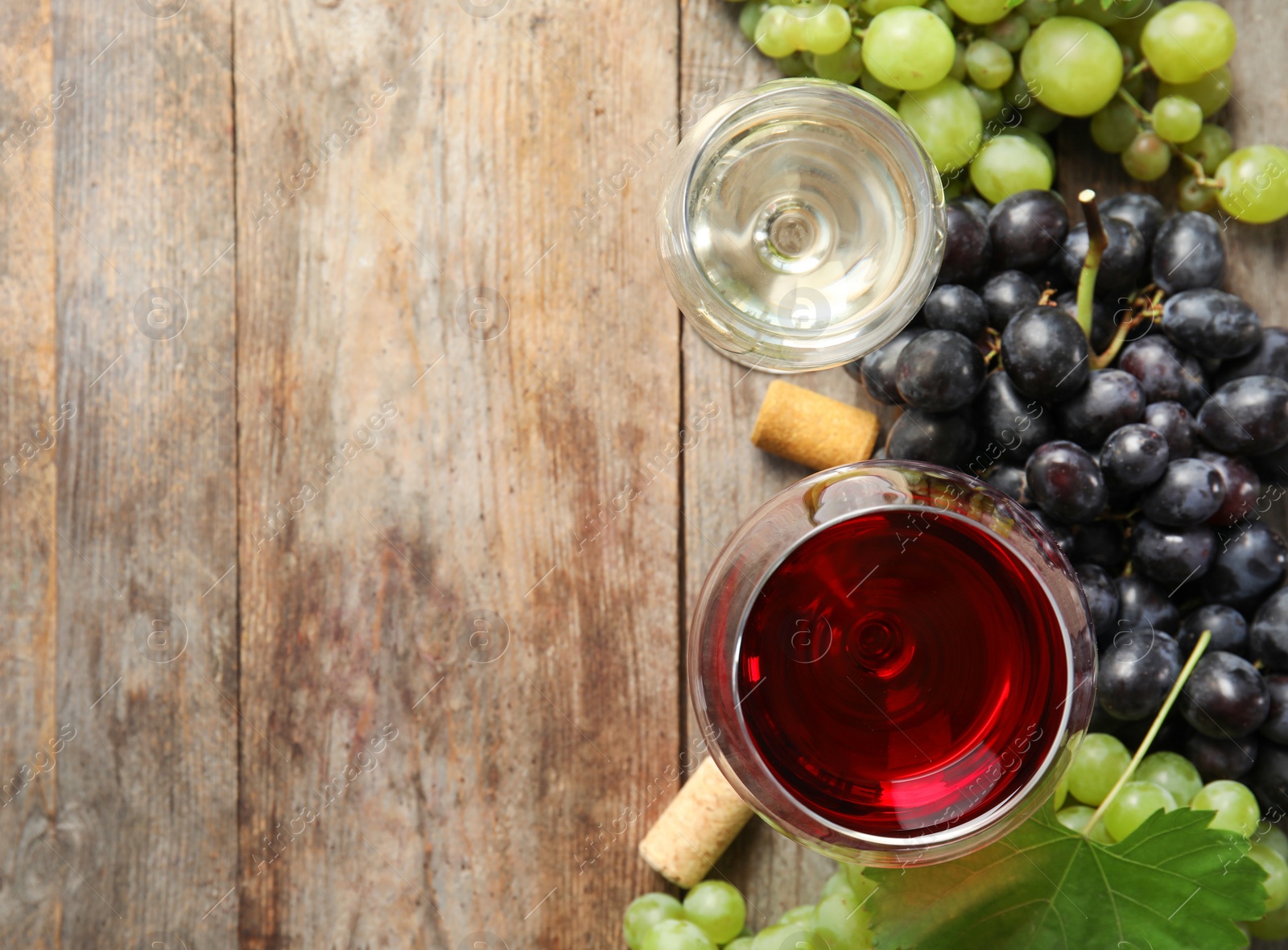 Photo of Flat lay composition with fresh ripe juicy grapes and space for text on wooden background