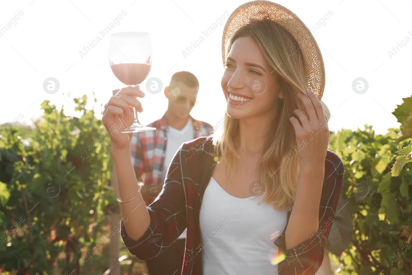 Photo of Beautiful woman with glass of wine at vineyard on sunny day