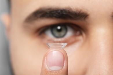 Photo of Young man with contact lens, focus on finger