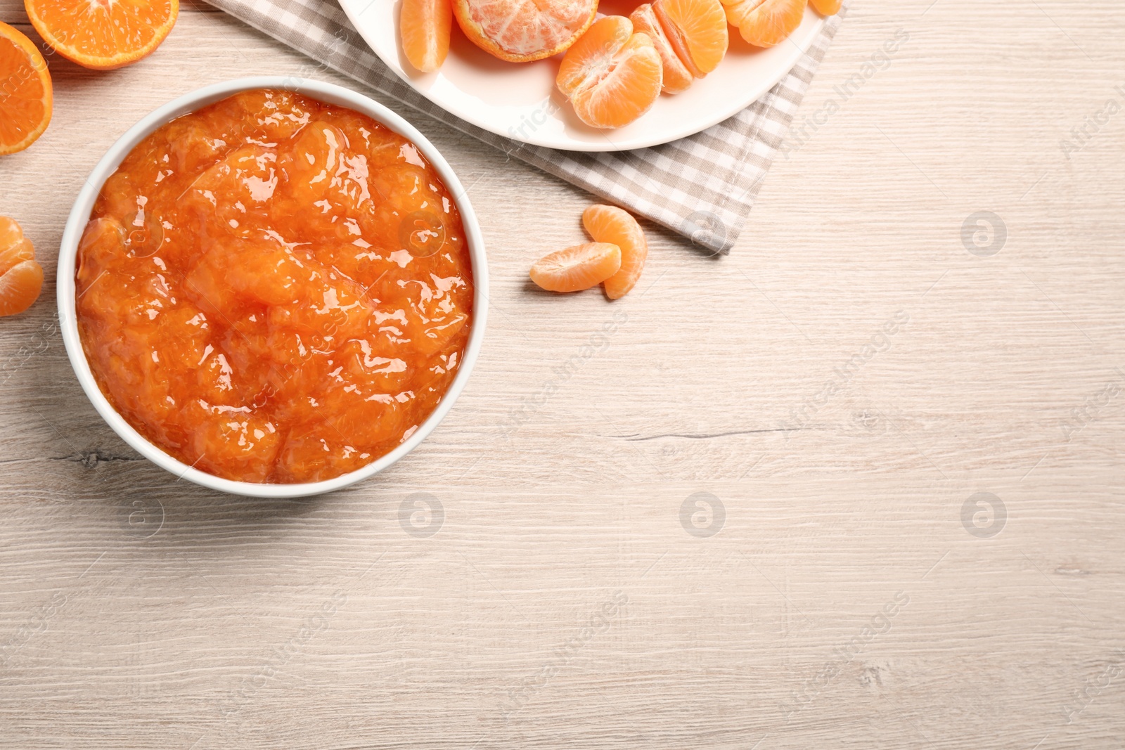 Photo of Flat lay composition with delicious tangerine jam on wooden table. Space for text