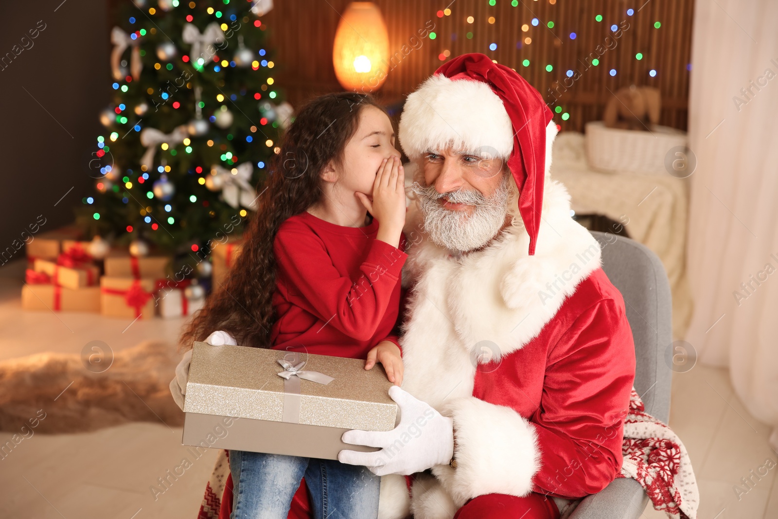 Photo of Little child with Santa Claus and Christmas gift at home