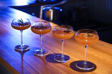 Glasses of delicious cocktail with vodka on wooden counter in bar