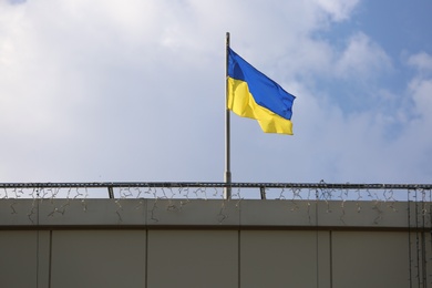 Photo of Ukrainian flag on building against cloudy sky