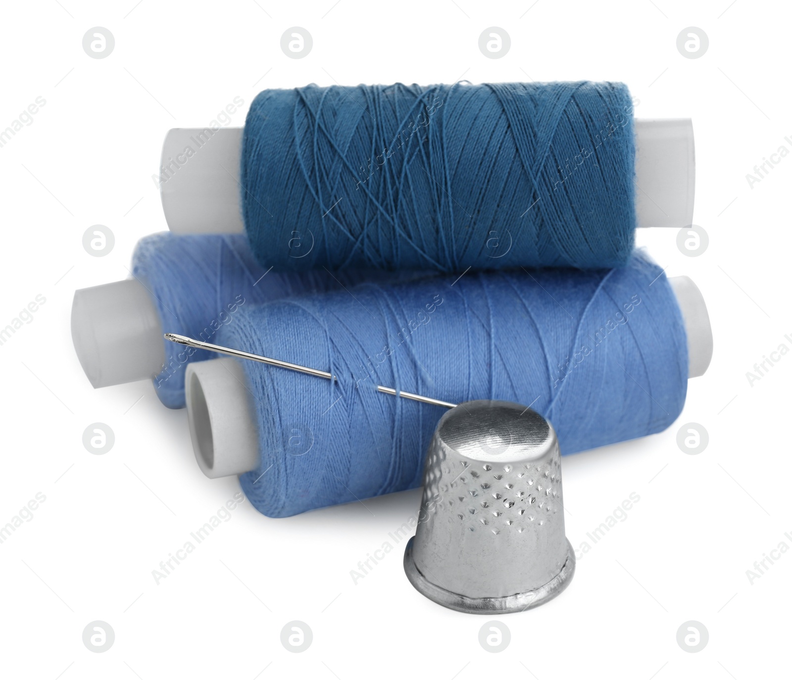 Photo of Thimble, spools of sewing threads and needle isolated on white