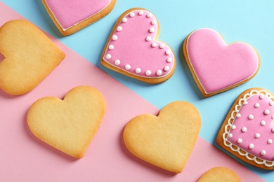 Decorated heart shaped cookies on color background, top view