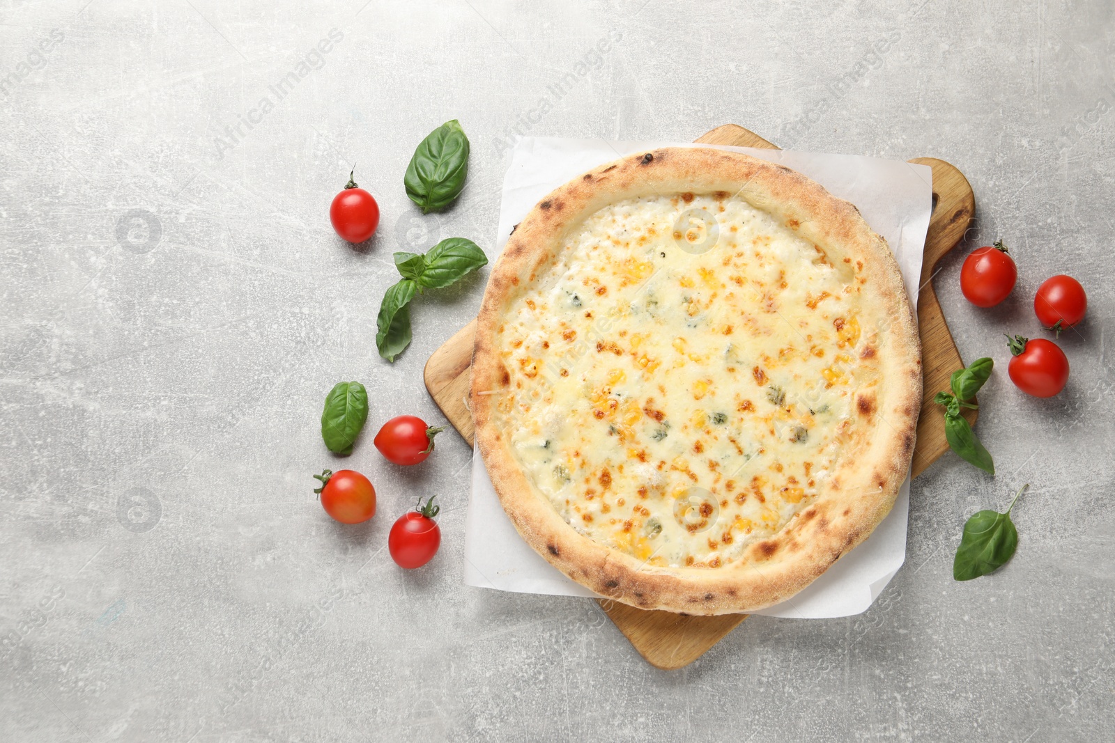 Photo of Delicious cheese pizza, basil and tomatoes on light grey table, flat lay. Space for text