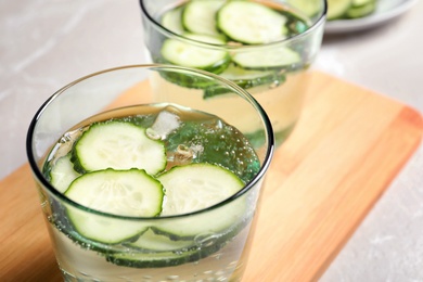 Photo of Glasses of fresh cucumber water on table, closeup