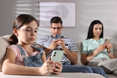 Photo of Internet addiction. Family with different gadgets on sofa at home