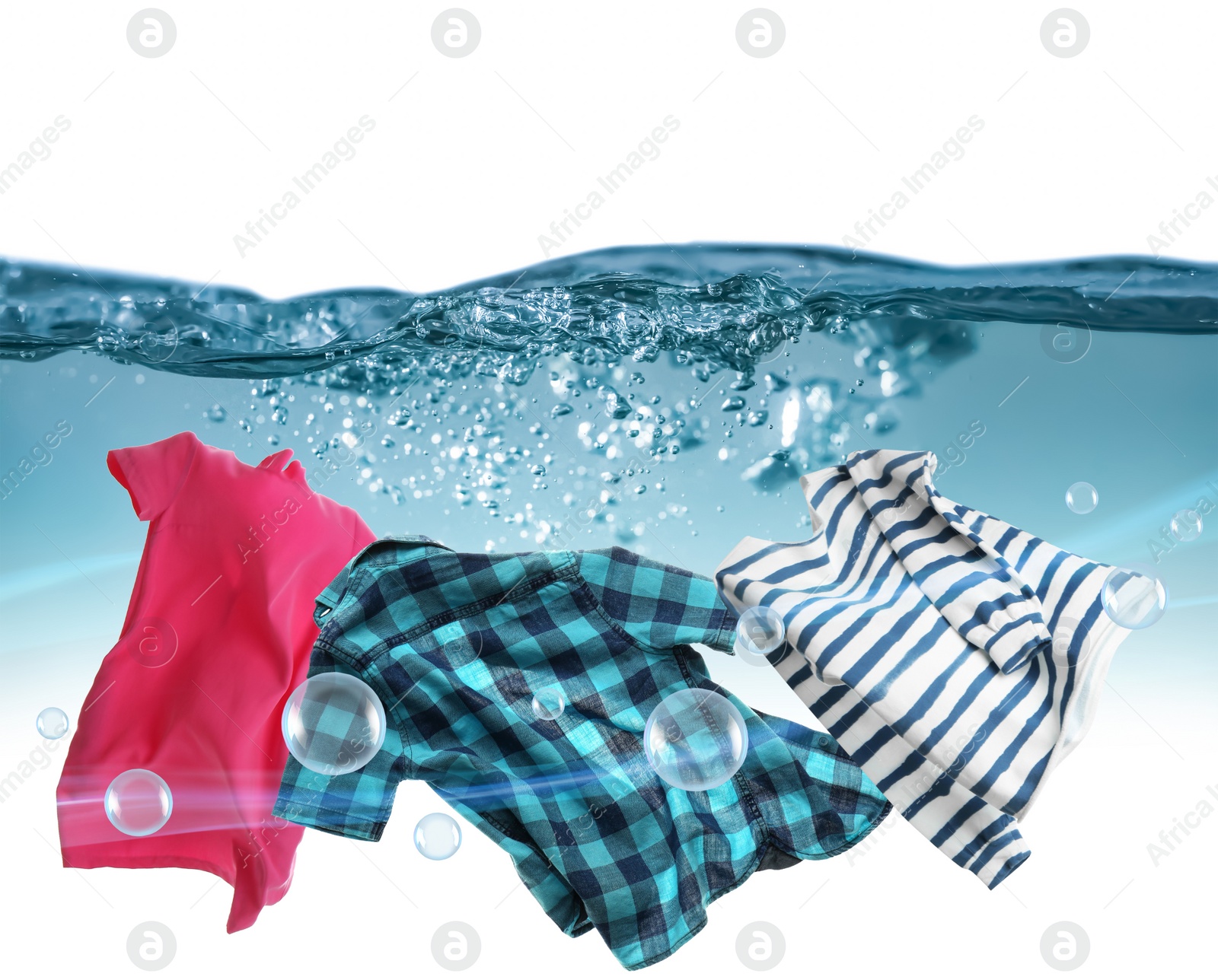 Image of Washing powder bubbles and clothes in water