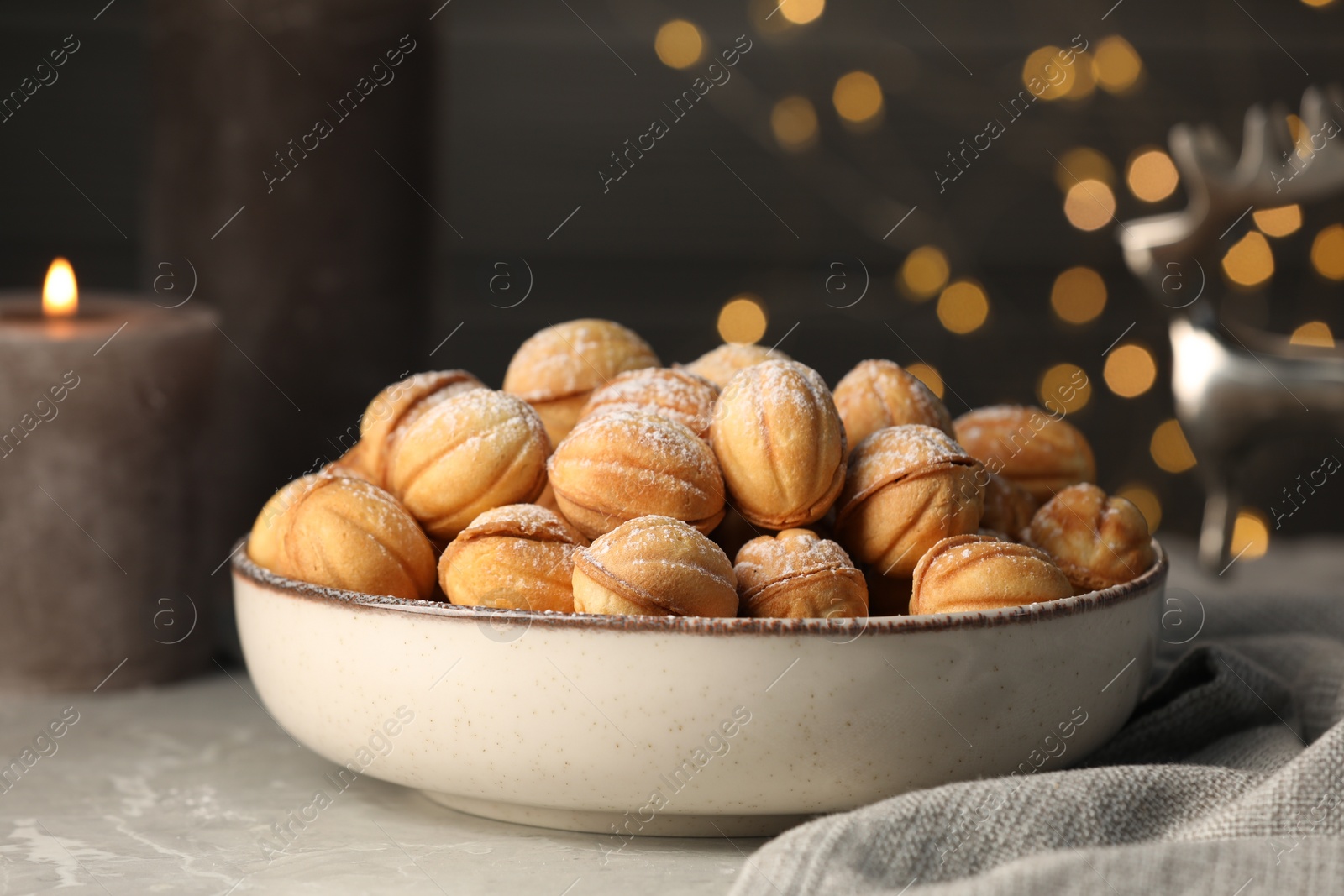 Photo of Bowl of delicious nut shaped cookies on grey table