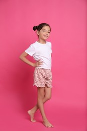 Photo of Cute girl in pajamas on pink background