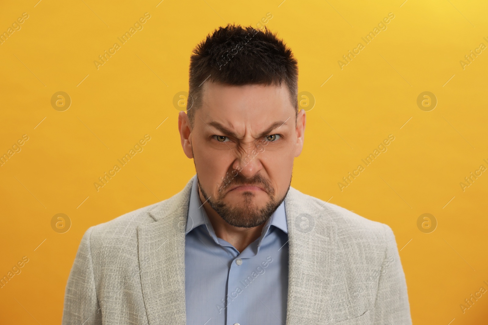 Photo of Angry man on yellow background. Hate concept