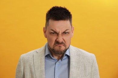 Photo of Angry man on yellow background. Hate concept