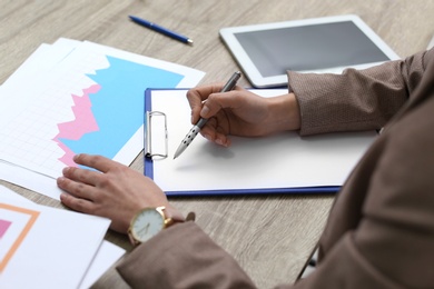 Businesswoman working with documents at office table, closeup