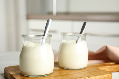 Photo of Tasty organic yogurt on wooden board indoors