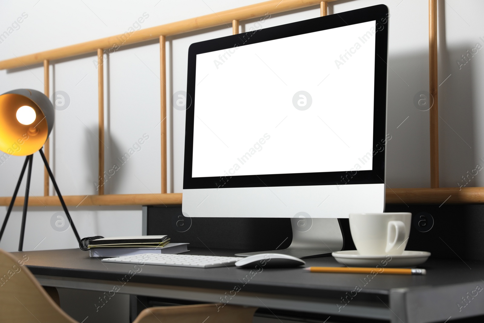 Photo of Modern computer with blank screen on black table indoors. Mockup for design