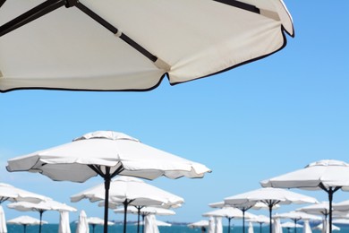 Photo of Beautiful white beach umbrellas against blue sky