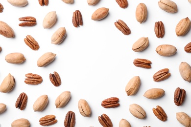 Photo of Frame made of pecan nuts on white background, top view with space for text