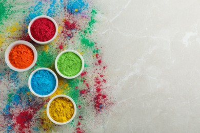 Photo of Colorful powder dyes on light marble background, flat lay with space for text. Holi festival