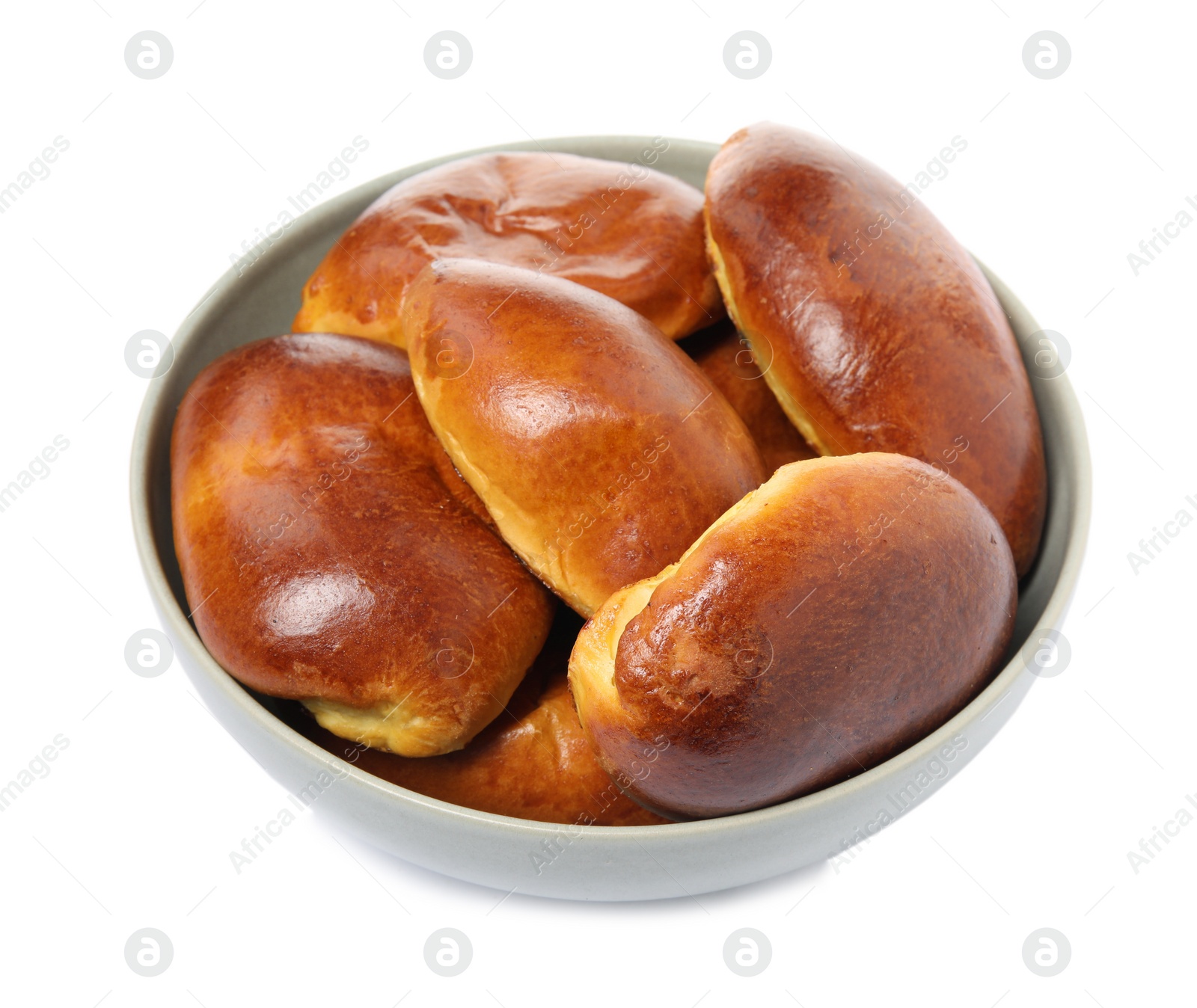 Photo of Bowl with delicious baked pirozhki on white background