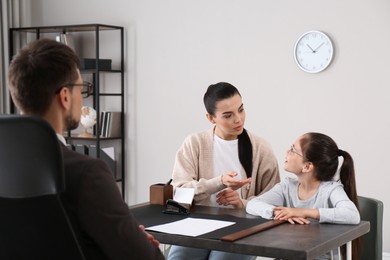 Mother and daughter having meeting with principal at school