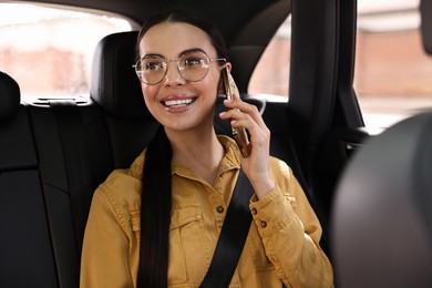 Woman with seatbelt talking on phone inside car