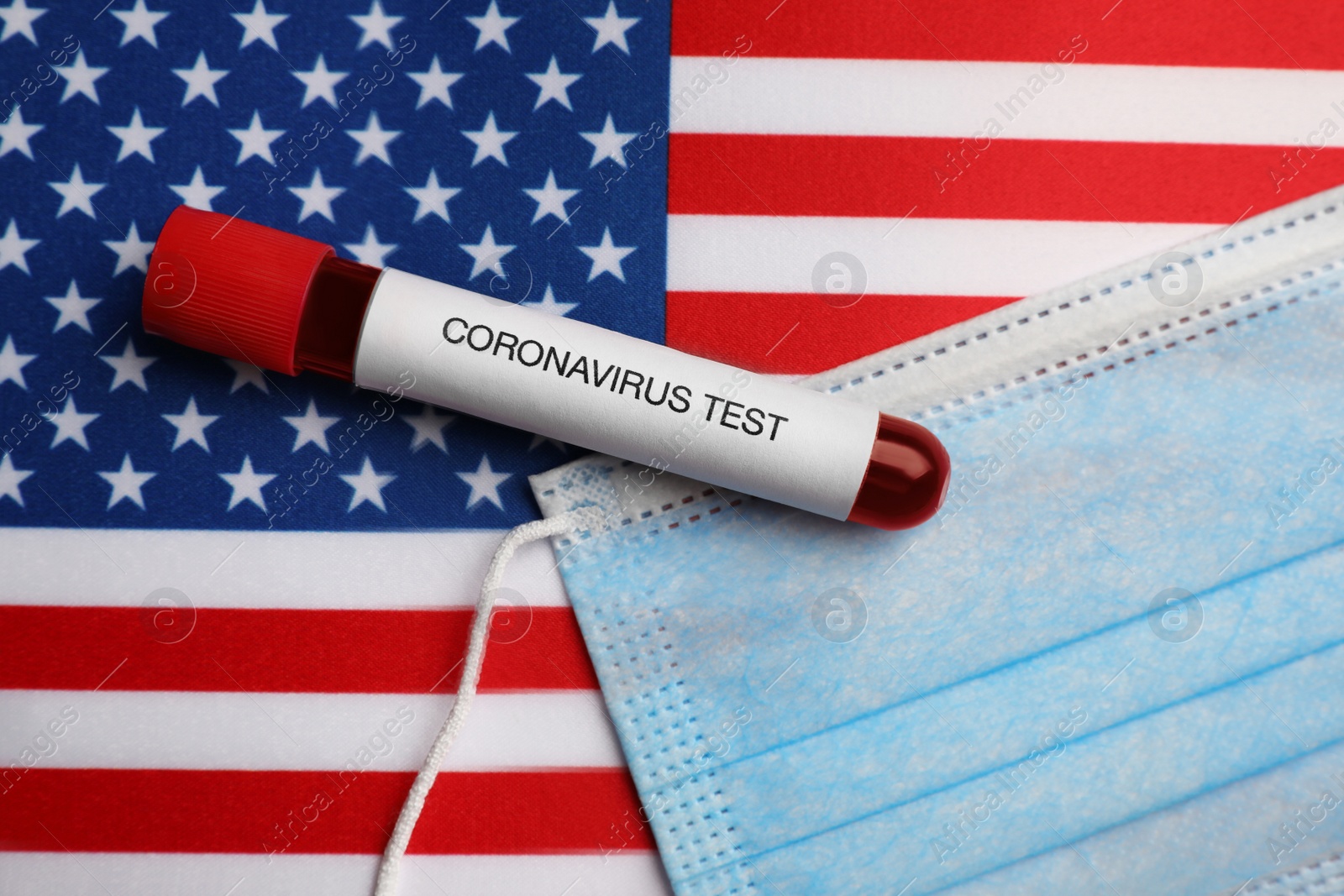 Photo of Test tube with blood sample and medical mask on American flag, flat lay. Coronavirus pandemic in USA