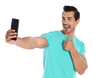 Photo of Happy young man taking selfie on white background