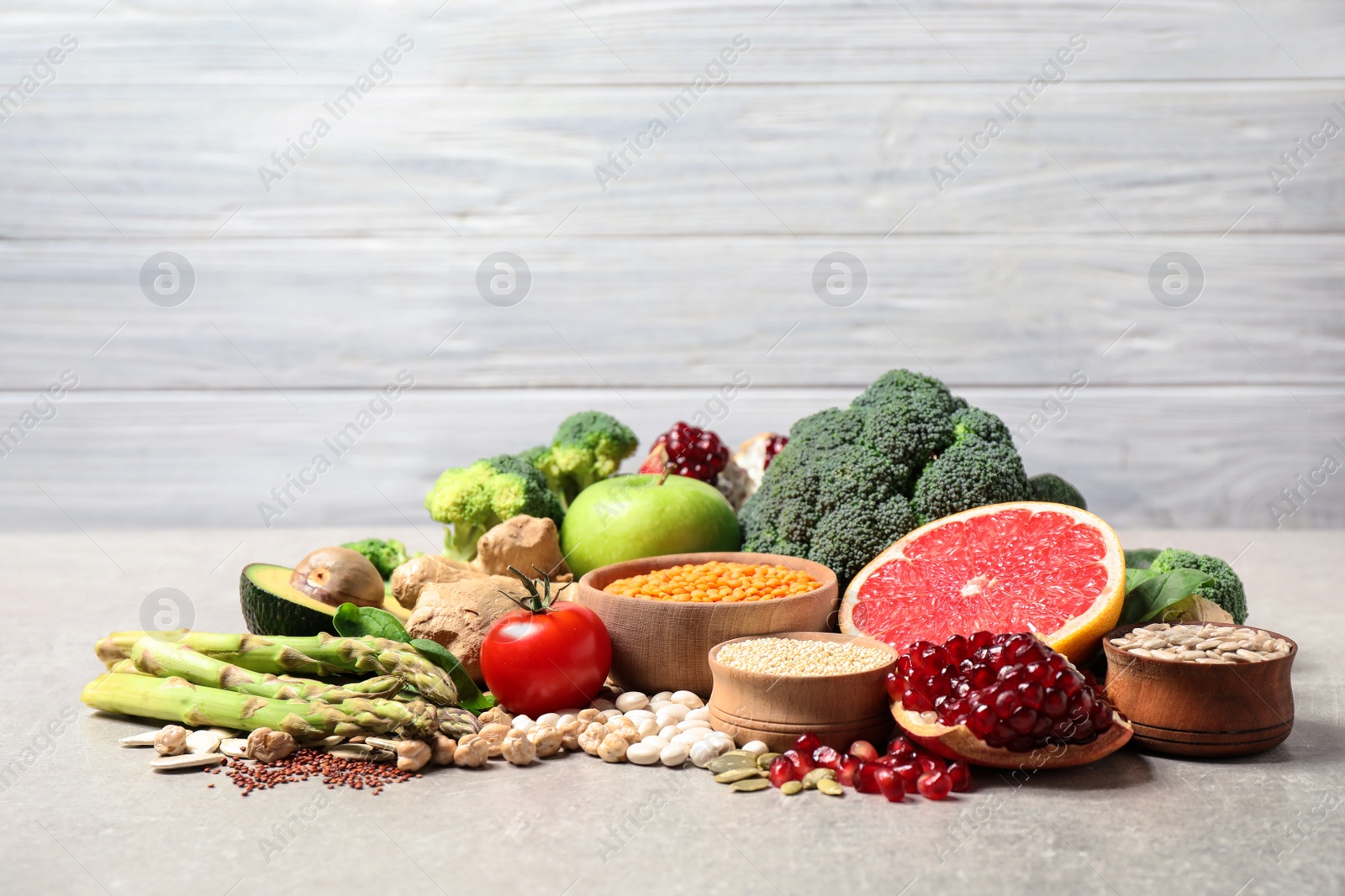 Photo of Fresh vegetables, fruits and seeds on grey table