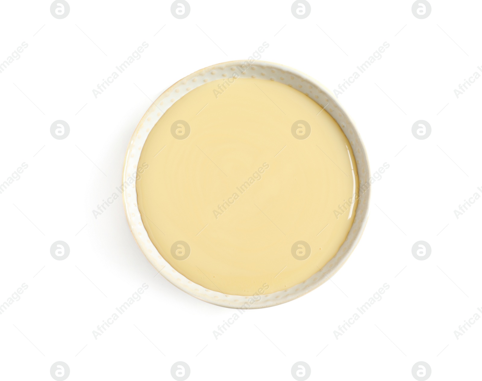 Photo of Bowl with condensed milk on white background, top view. Dairy product