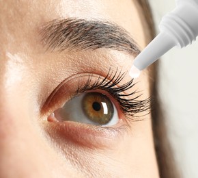 Woman applying eye drops on light background, closeup