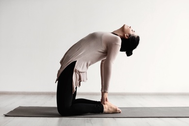 Photo of Sporty woman practicing yoga indoors