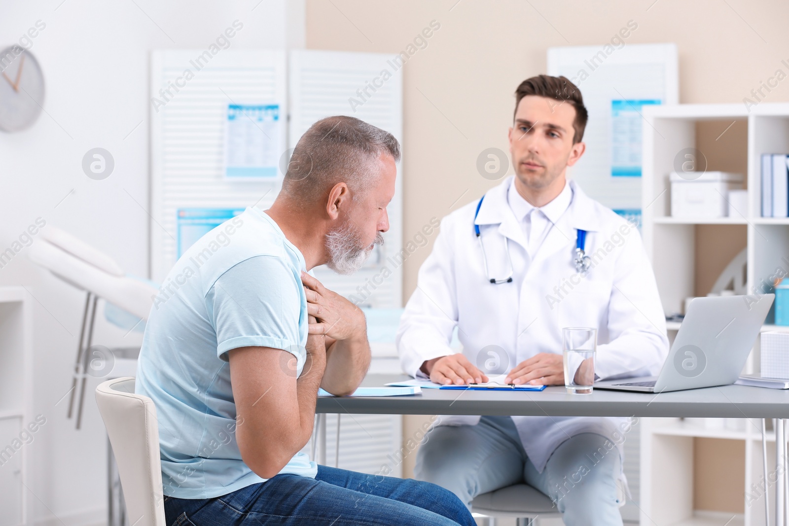 Photo of Coughing mature man visiting doctor at clinic