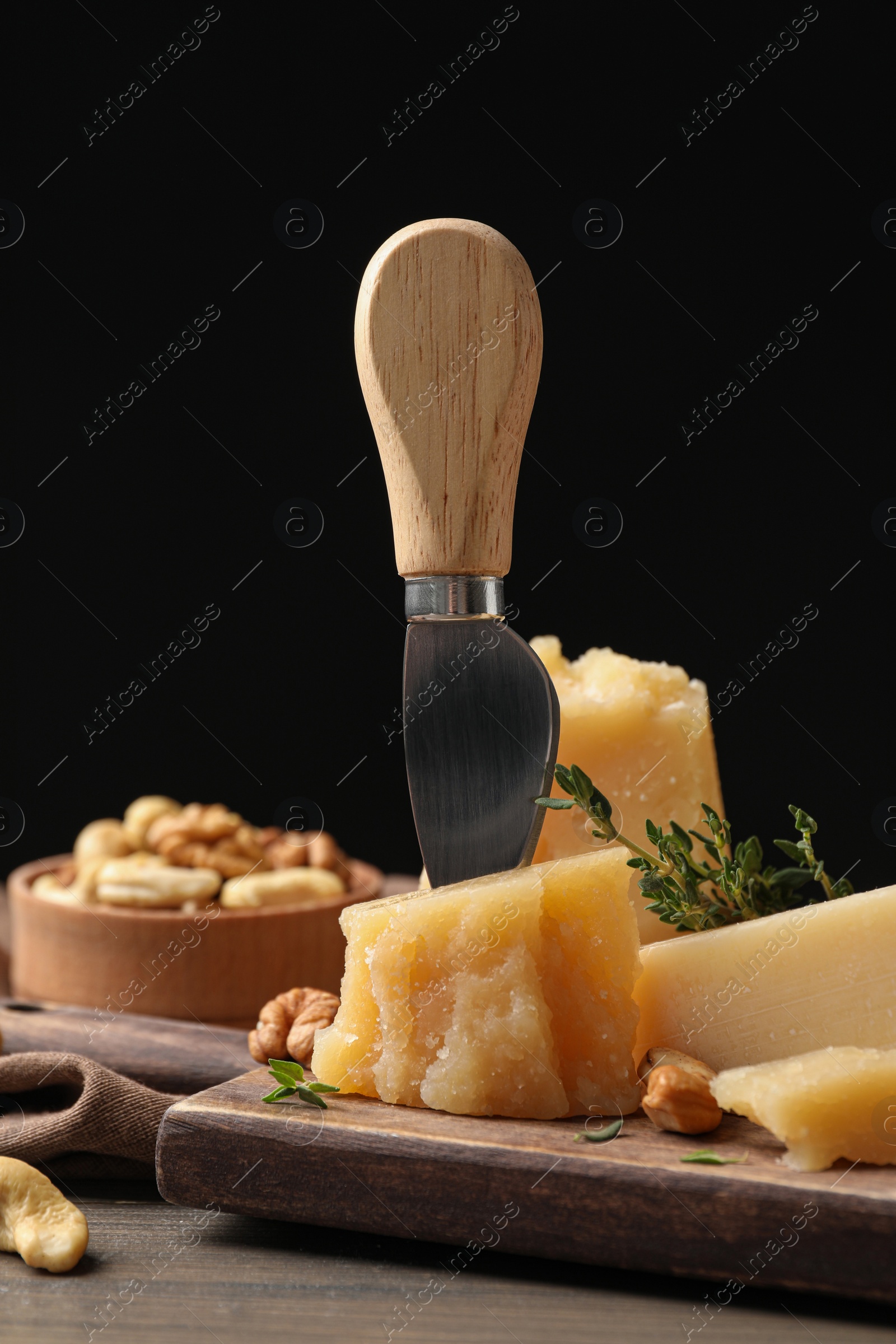 Photo of Delicious parmesan cheese with walnuts and rosemary on wooden table