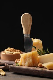 Photo of Delicious parmesan cheese with walnuts and rosemary on wooden table
