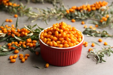 Fresh ripe sea buckthorn in bowl on grey table