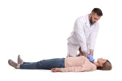 Photo of Doctor in uniform performing first aid on unconscious woman against white background